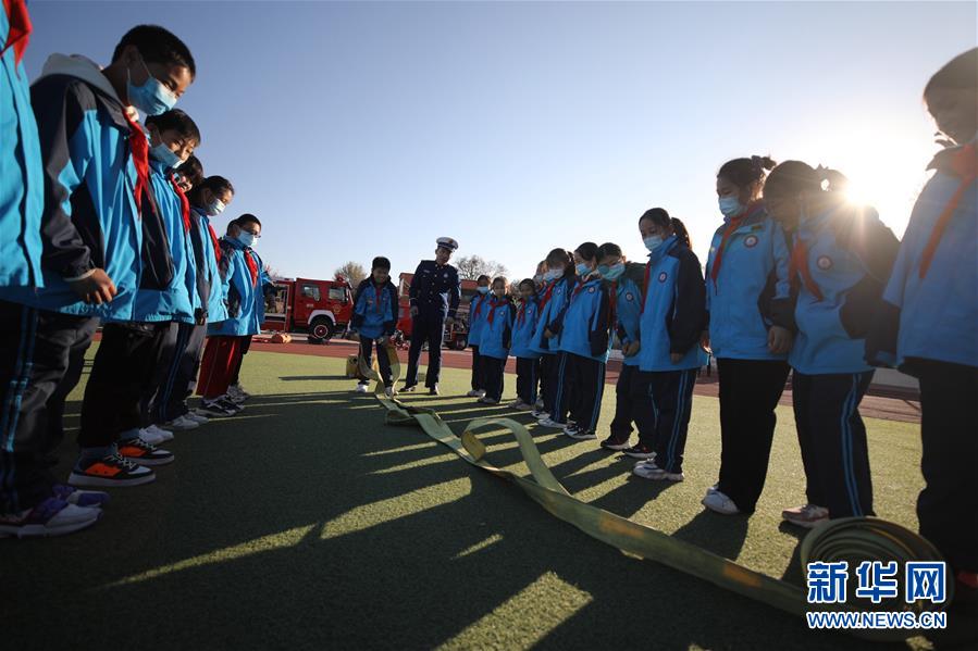 11月3日，在承德市雙橋區(qū)普寧小學，學生在消防救援人員指導下體驗使用消防器材。 當日，河北省承德市雙橋區(qū)消防救援大隊與普寧小學聯(lián)合開展消防進校園安全互動體驗教育活動。學生們通過體驗救生設備、安全使用消防器材等，在互動活動中學習消防知識，提升自救能力，迎接“119消防宣傳日”。 新華社發(fā)（劉環(huán)宇 攝）