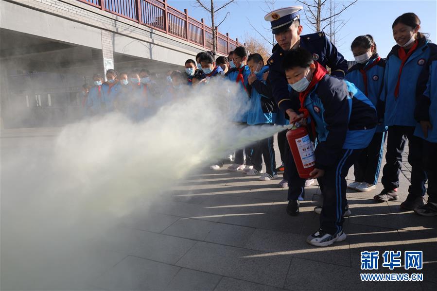 11月3日，在承德市雙橋區(qū)普寧小學，學生在消防救援人員指導下學習使用滅火器。 當日，河北省承德市雙橋區(qū)消防救援大隊與普寧小學聯(lián)合開展消防進校園安全互動體驗教育活動。學生們通過體驗救生設備、安全使用消防器材等，在互動活動中學習消防知識，提升自救能力，迎接“119消防宣傳日”。 新華社發(fā)（劉環(huán)宇 攝）
