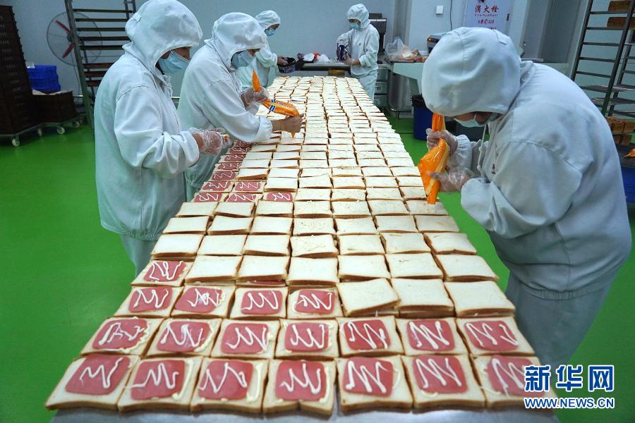 資溪縣面包食品產(chǎn)業(yè)城內(nèi)一家面包企業(yè)的工人在制作三明治（11月11日攝）。近年來，江西省資溪縣通過建設(shè)面包食品產(chǎn)業(yè)城、舉辦面包文化節(jié)、構(gòu)建面包全產(chǎn)業(yè)鏈等舉措，帶動(dòng)當(dāng)?shù)厝罕娫鍪罩赂?。?jù)了解，資溪縣12.6萬人口中有近5萬人從事面包及相關(guān)產(chǎn)業(yè)，有“中國(guó)面包之鄉(xiāng)”稱號(hào)。新華社記者 萬象 攝