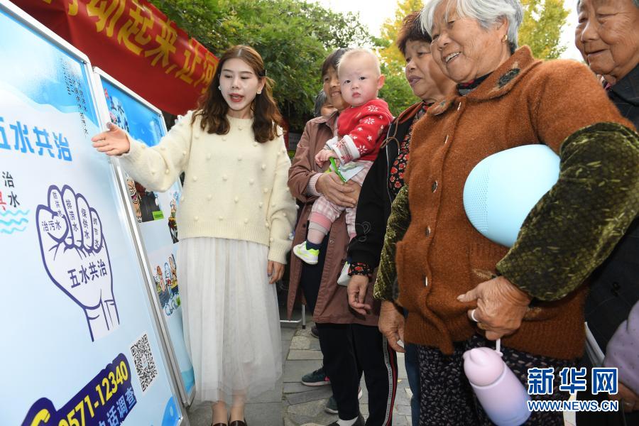 11月16日，宣講員（左一）向藤橋港河道沿岸玉堂橋社區(qū)的居民進(jìn)行“五水共治”宣傳。2013年起，浙江湖州吳興區(qū)環(huán)渚街道開始對(duì)轄區(qū)內(nèi)污染較嚴(yán)重的藤橋港河道進(jìn)行整治，強(qiáng)化落實(shí)河長(zhǎng)制，加大水生植物種植率，并通過手機(jī)APP及時(shí)上報(bào)巡河問題，使河道水環(huán)境面貌和水質(zhì)獲得明顯改善。新華社記者 翁忻旸 攝