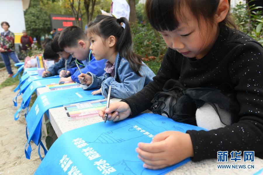 11月16日，小學(xué)生在藤橋港河道沿岸繪制公益宣傳袋，準(zhǔn)備分發(fā)給當(dāng)?shù)鼐用瘛?013年起，浙江湖州吳興區(qū)環(huán)渚街道開始對(duì)轄區(qū)內(nèi)污染較嚴(yán)重的藤橋港河道進(jìn)行整治，強(qiáng)化落實(shí)河長(zhǎng)制，加大水生植物種植率，并通過手機(jī)APP及時(shí)上報(bào)巡河問題，使河道水環(huán)境面貌和水質(zhì)獲得明顯改善。新華社記者 翁忻旸 攝