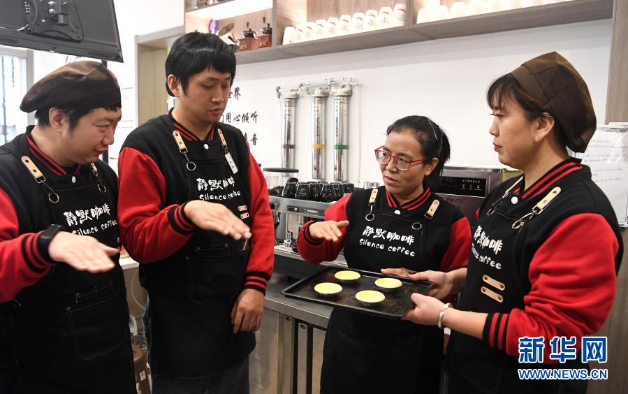 西安“靜默咖啡”的店長(zhǎng)王麗超（右二）指導(dǎo)三名店員制作蛋撻（12月1日攝）。新華社記者 劉瀟攝