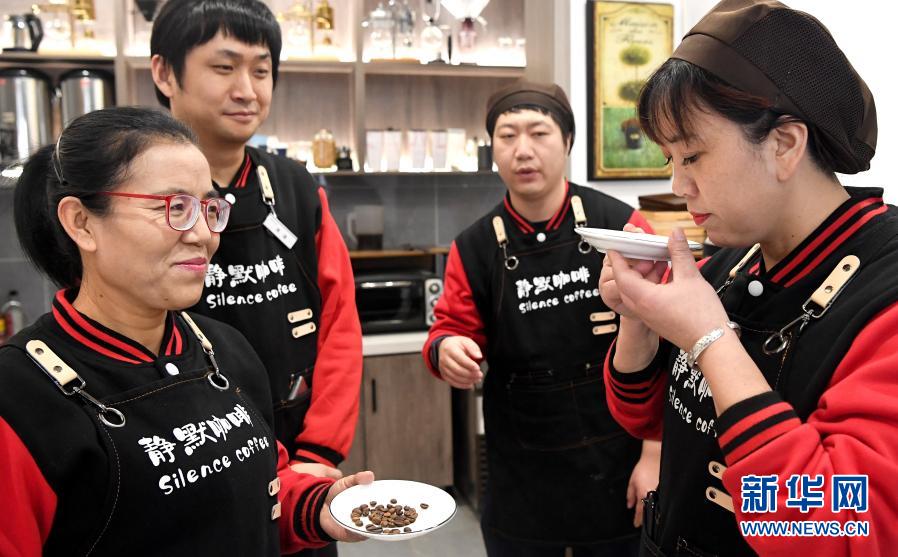 西安“靜默咖啡”的店長(zhǎng)王麗超（左一）教授三名店員分辨不同咖啡豆的氣味（12月1日攝）。新華社記者 劉瀟攝