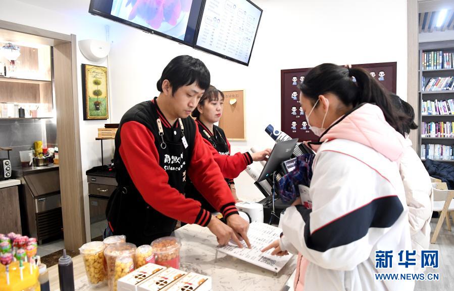 西安“靜默咖啡”的店員李濤和曹瑞華為顧客點(diǎn)單（12月1日攝）。新華社記者 劉瀟攝