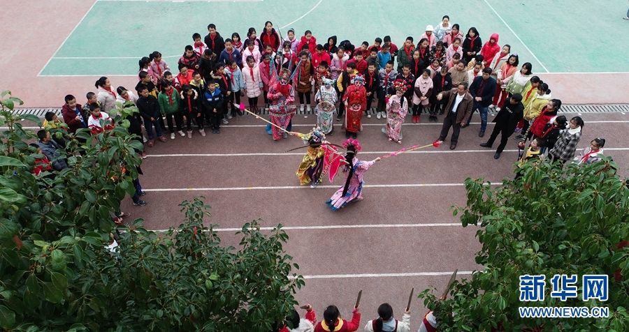 12月1日，天柱縣渡馬鎮(zhèn)小學的學生在排練侗戲（無人機照片）。貴州省天柱縣渡馬鎮(zhèn)小學有一個侗戲班，侗戲班常年堅持定期進行侗戲排練，讓小學生感受傳統(tǒng)戲曲的魅力。近年來，天柱縣通過侗戲進校園等形式，讓侗戲不斷傳承。新華社發(fā)（金可文 攝）