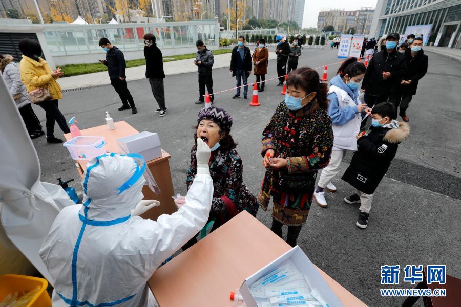 12月10日，在郫都區(qū)中醫(yī)醫(yī)院核酸檢測點，醫(yī)務(wù)人員對居民進行核酸取樣。自12月7日成都市郫都區(qū)新增新冠肺炎本土確診病例以來，郫都區(qū)中醫(yī)醫(yī)院進入24小時連軸轉(zhuǎn)狀態(tài)。該院信息科技術(shù)人員通宵達旦設(shè)計上線核酸檢測微信小程序，方便人們在手機上查看檢測報告。核酸檢測室的14名檢測員24小時3班倒，日均完成2000多份核酸檢測?！捌幢M全力與病毒爭分奪秒！”檢測科主任孔麗蕊說。新華社記者 沈伯韓 攝