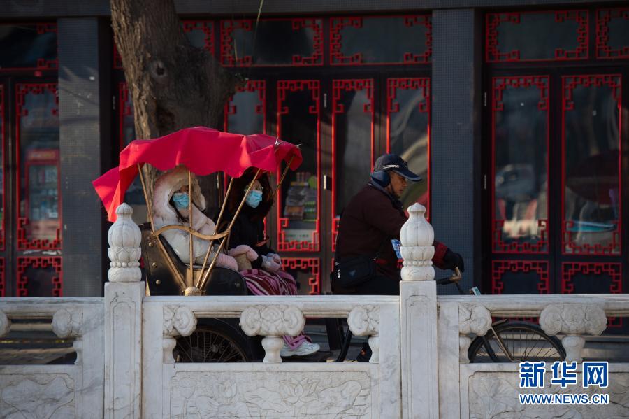 12月13日，游人乘坐人力三輪車(chē)欣賞什剎海風(fēng)景。當(dāng)日，天氣晴好，位于北京東城區(qū)的什剎海景區(qū)艷陽(yáng)高照，滄桑的古建筑、結(jié)冰的湖水、悠閑的游人……呈現(xiàn)一幅別樣的古都冬景圖。新華社記者 陳鐘昊 攝