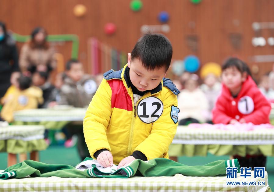 12月21日，四川省華鎣市清溪路幼兒園的小朋友在參加疊衣服比賽。新華社發(fā)（邱海鷹 攝）