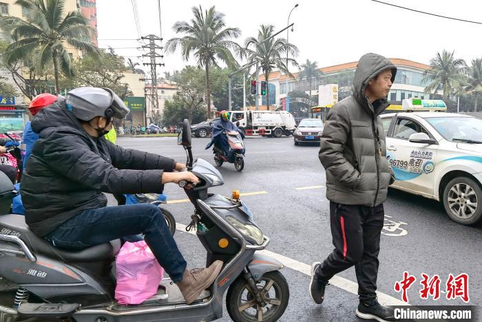 1月7日，海南?？冢腥舜┥隙b御寒。　尹海明 攝