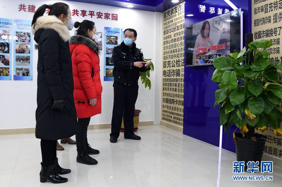 1月10日，在北京市公安局海淀分局永定路派出所第三社區(qū)警務(wù)工作站展示區(qū)，社區(qū)民警屈超直（右一）向社區(qū)居民介紹防詐騙知識。當(dāng)日是首個中國人民警察節(jié)，在做好疫情防控的前提下，北京市公安局海淀分局永定路派出所第三社區(qū)警務(wù)工作站舉辦警務(wù)開放日活動。社區(qū)居民在警務(wù)工作站展示區(qū)通過社區(qū)民警的介紹了解防盜、防詐騙、禁毒等知識。新華社記者 任超 攝