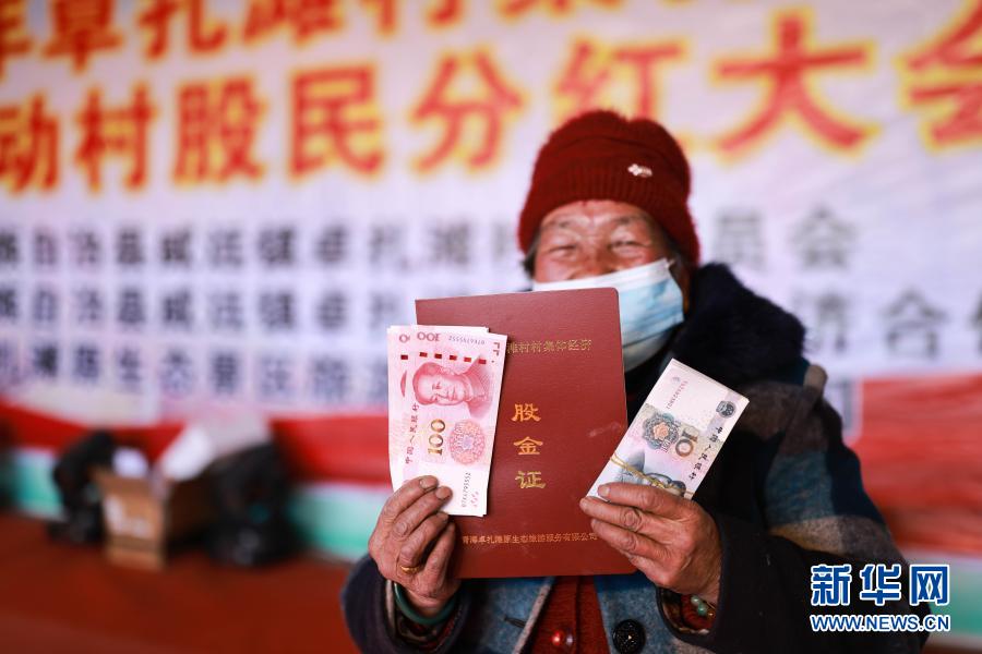 1月18日，卓扎灘村民雷良梅展示領(lǐng)取到的分紅資金。當(dāng)日，位于青海省海東市互助土族自治縣威遠(yuǎn)鎮(zhèn)的卓扎灘村迎來“分紅日”，1820名入股村民領(lǐng)取了青海卓扎灘原生態(tài)景區(qū)旅游服務(wù)有限公司的120萬元年度經(jīng)營分紅及面粉和大米。2018年，卓扎灘村村民以自愿入股的方式參與景區(qū)建設(shè)，2019年開始領(lǐng)取“分紅”，通過發(fā)展鄉(xiāng)村旅游，享受旅游收益。新華社記者 張曼怡 攝