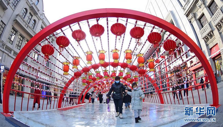 2月1日，在沈陽中街，市民從花燈下走過。春節(jié)臨近，年味漸濃，在遼寧沈陽中街步行街，福牛藝術雕塑和各色花燈吸引了眾多市民觀看拍照。新華社記者 楊青 攝