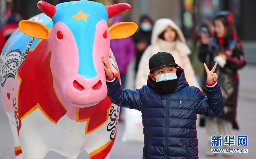 2月1日，一名小朋友在福牛藝術雕塑前拍照。春節(jié)臨近，年味漸濃，在遼寧沈陽中街步行街，福牛藝術雕塑和各色花燈吸引了眾多市民觀看拍照。新華社記者 楊青 攝