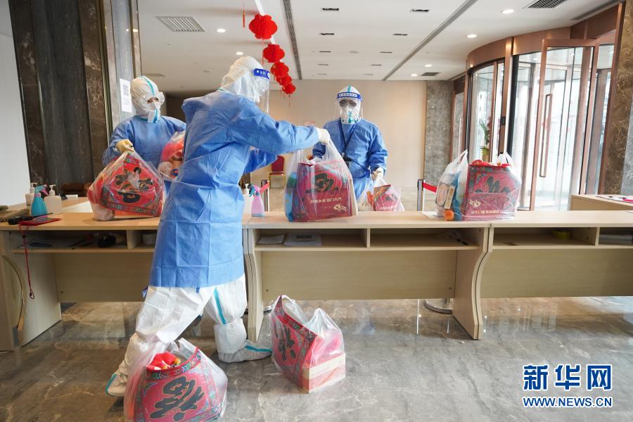 　　2月11日，在北京市大興區(qū)一處集中醫(yī)學(xué)觀察點(diǎn)，身穿防護(hù)服的工作人員將準(zhǔn)備的新春禮包分裝，準(zhǔn)備送到隔離人員房間內(nèi)?！　‘?dāng)日是除夕，在北京市大興區(qū)一處集中醫(yī)學(xué)觀察點(diǎn)內(nèi)，工作人員為隔離觀察人員準(zhǔn)備了新春禮包，將“福”字和餃子送到隔離觀察人員手中，讓他們?cè)诩嗅t(yī)學(xué)觀察點(diǎn)內(nèi)也能感受到年味?！　⌒氯A社記者 鞠煥宗 攝