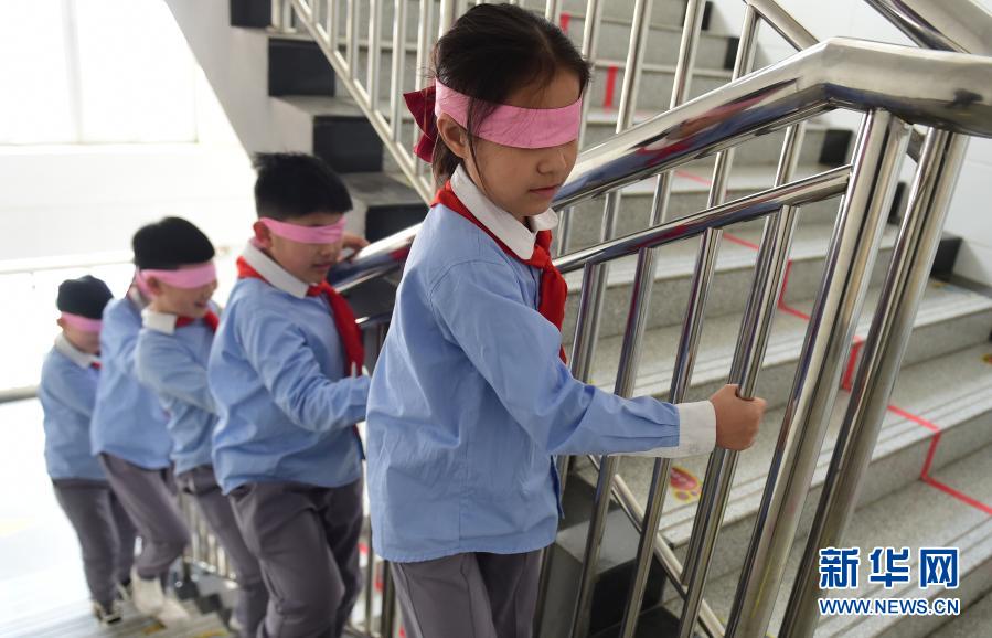 　　3月22日，滄州市實驗小學的學生蒙著雙眼上樓梯，體驗視覺障礙帶來的不便?！　‘斎眨颖笔嬷菔袑嶒炐W邀請滄州眼科醫(yī)院的“眼衛(wèi)士”醫(yī)生志愿服務隊走進校園，開展愛眼護眼公益講座，并為孩子們進行視力健康普查，建立“視力檔案”。今年3月是教育部部署的春季學期近視防控宣傳教育月。新華社發(fā)（傅新春 攝）