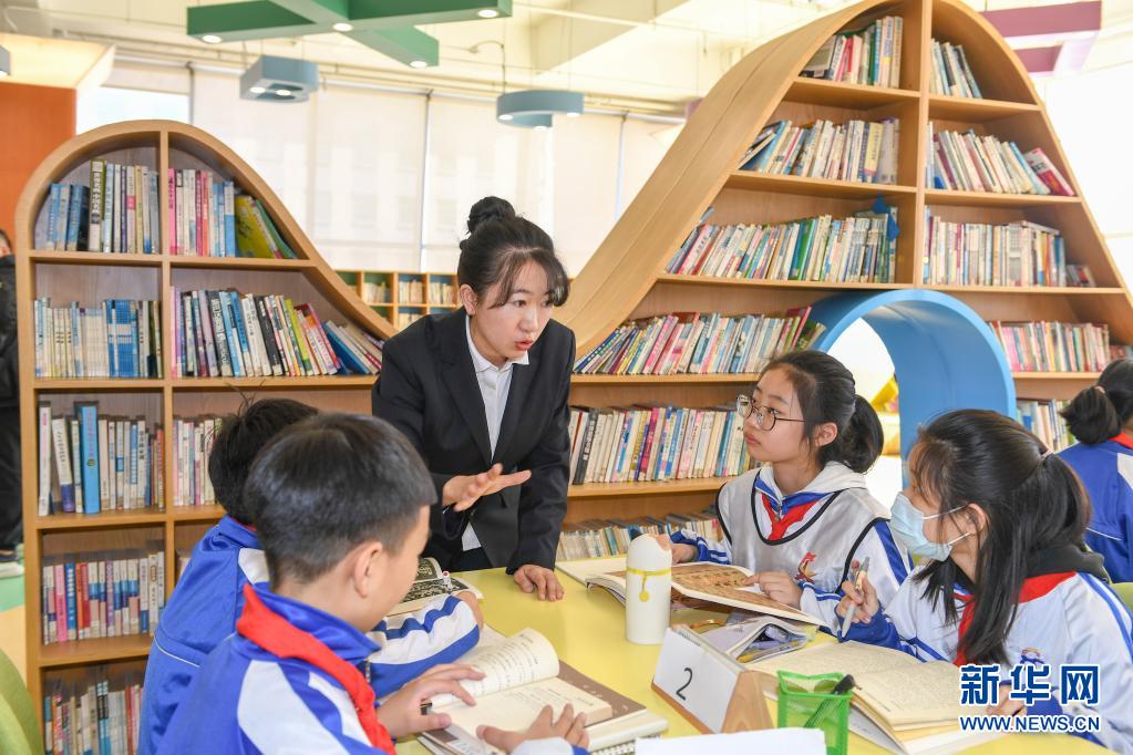 　　3月25日，在長春市第八十七中學(xué)圖書館，小學(xué)部教師孫銘輔導(dǎo)學(xué)生閱讀書籍?！　￠L春市第八十七中學(xué)小學(xué)部從2018年開始，探索引導(dǎo)學(xué)生用繪畫加文字的形式完成語文閱讀摘抄作業(yè)，在不額外增加學(xué)生作業(yè)負(fù)擔(dān)的前提下，培養(yǎng)學(xué)生的閱讀習(xí)慣?！　⌒氯A社記者 張楠 攝