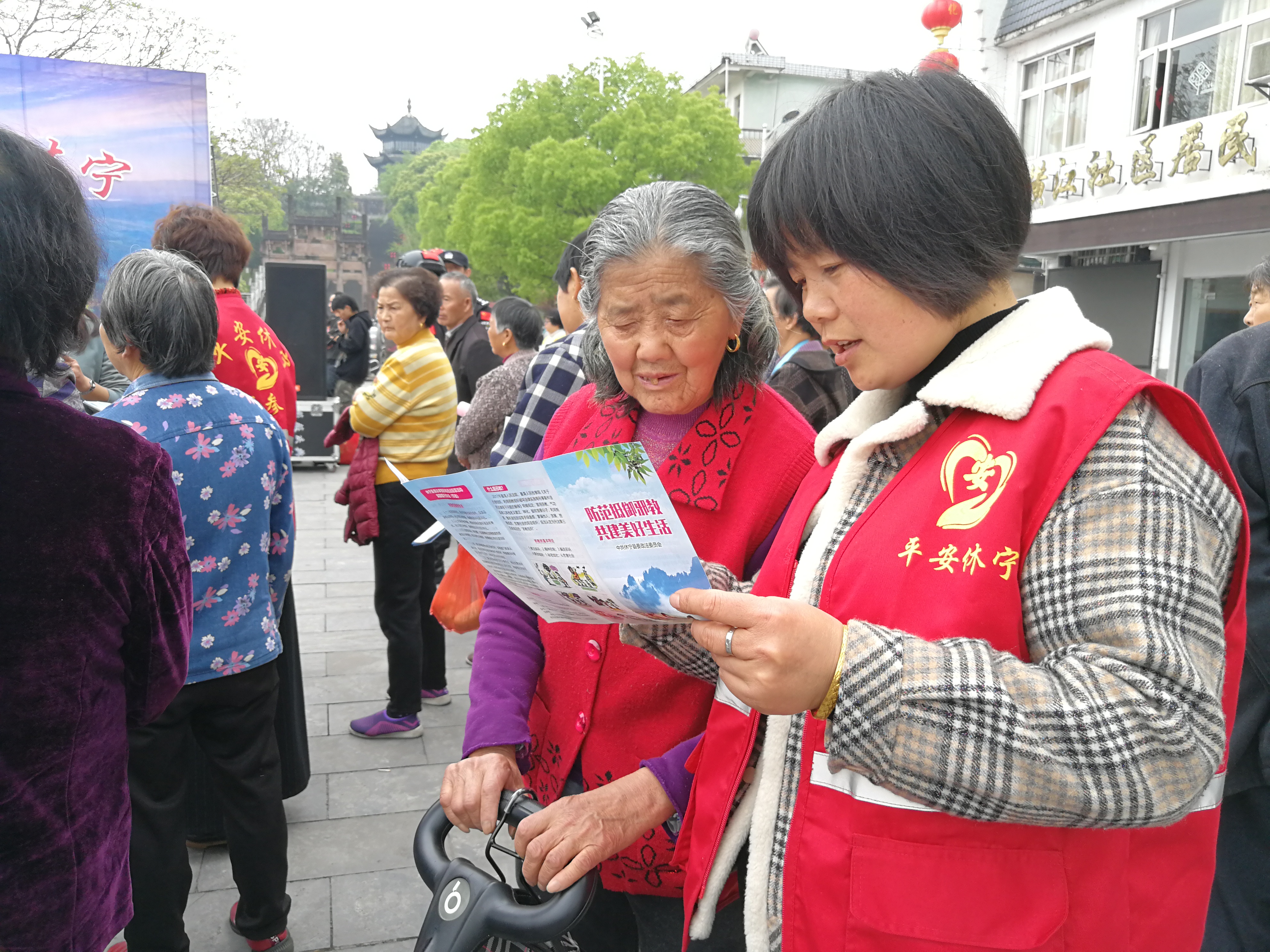 平安休寧志愿者積極參與反邪教法治宣傳活動(dòng)，在活動(dòng)現(xiàn)場(chǎng)向群眾耐心介紹反邪教知識(shí)