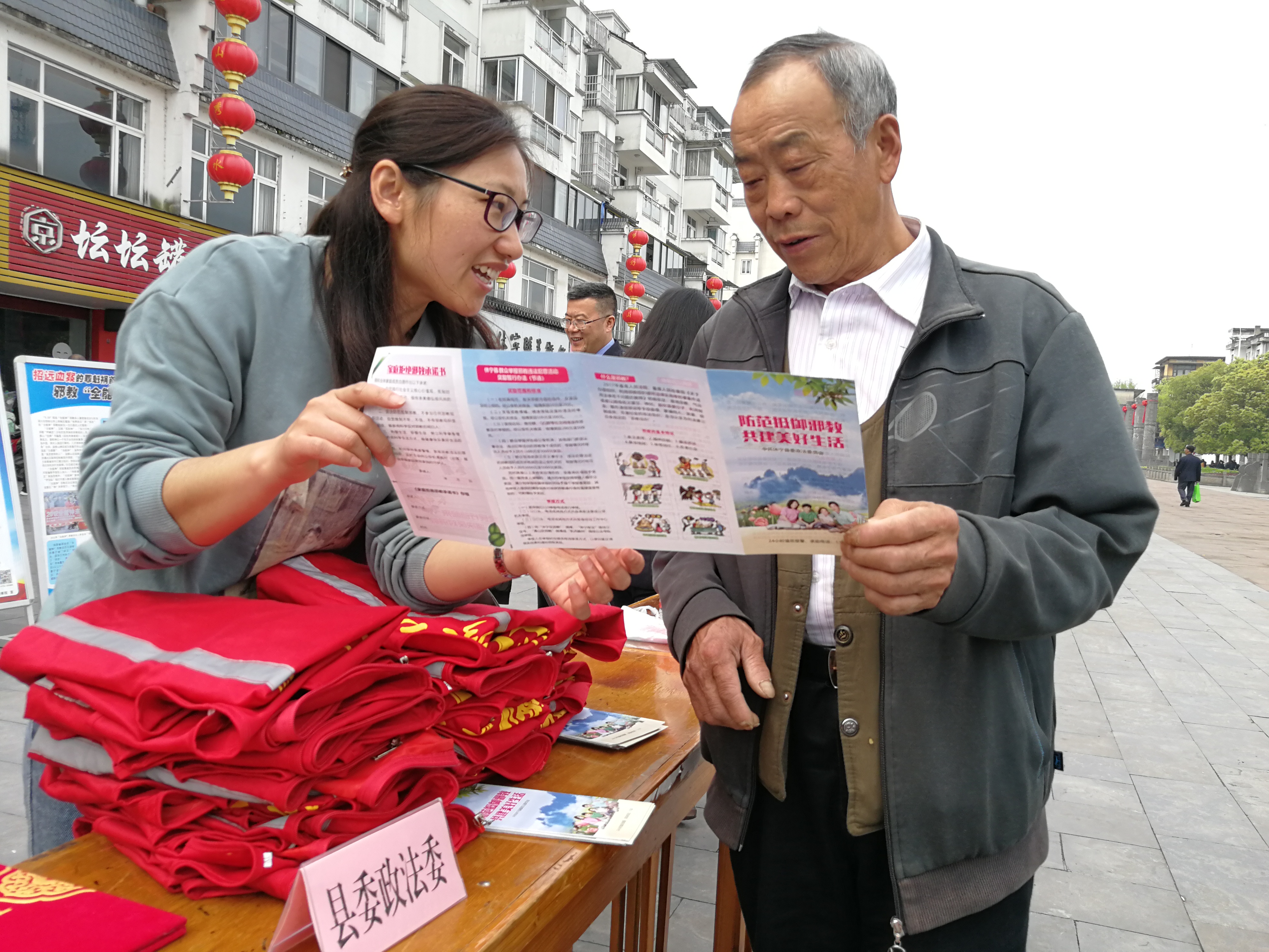 休寧縣政法委工作人員向群眾發(fā)放反邪教宣傳冊(cè)，介紹反邪教基本常識(shí)