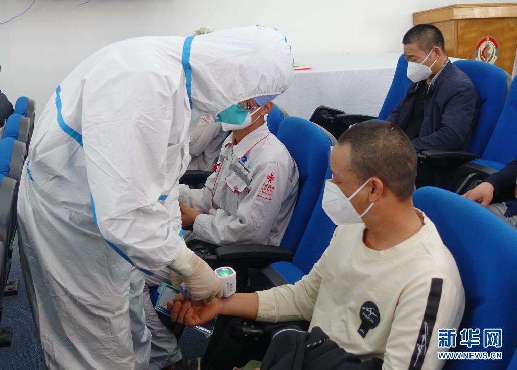 4月14日，在突尼斯首都突尼斯市，工作人員為一名準備接種新冠疫苗的中國公民檢查體溫。在中國駐突尼斯大使館協(xié)調推動下，突尼斯軍事醫(yī)院14日開始為中國公民接種中國科興新冠疫苗，標志著“春苗行動”在突正式啟動。新華社發(fā)